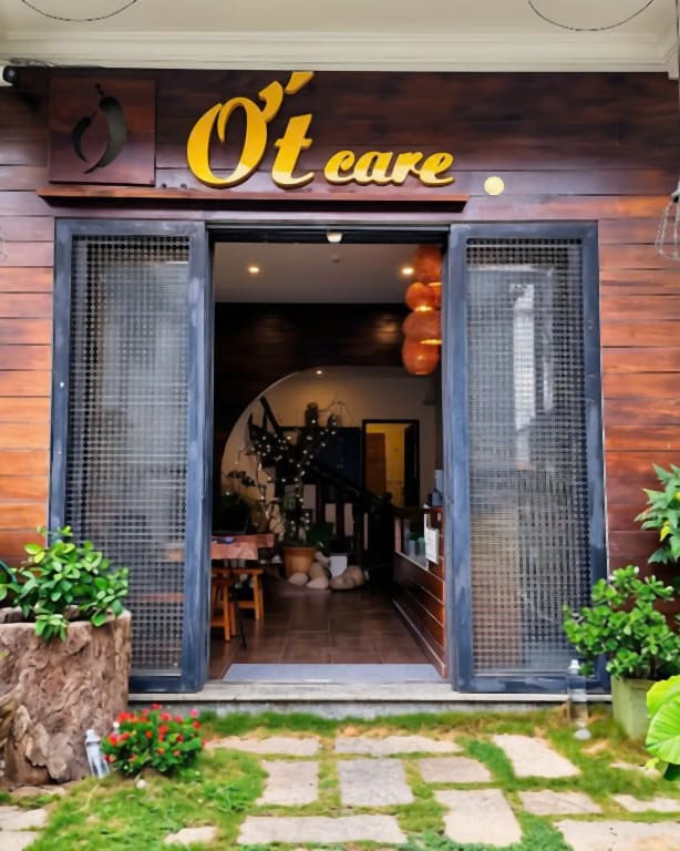 Lối vào Ớt Care Spa — cổng gỗ và biển đèn vàng